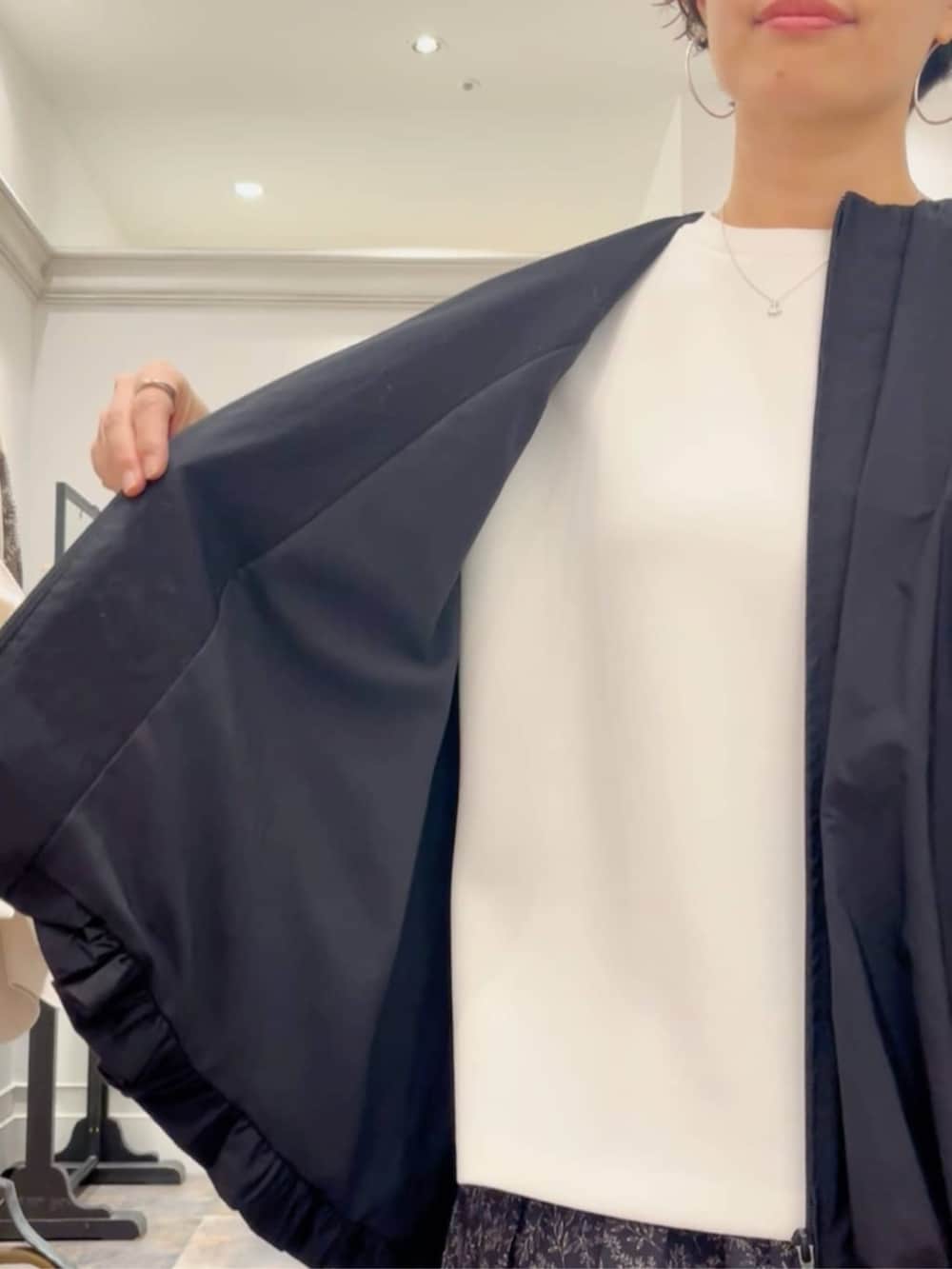 ブラック系のスカート、ベージュ系のショルダーバッグ、ブラック系のブルゾンを着用したレディースの冬コーディネートの6枚目の写真