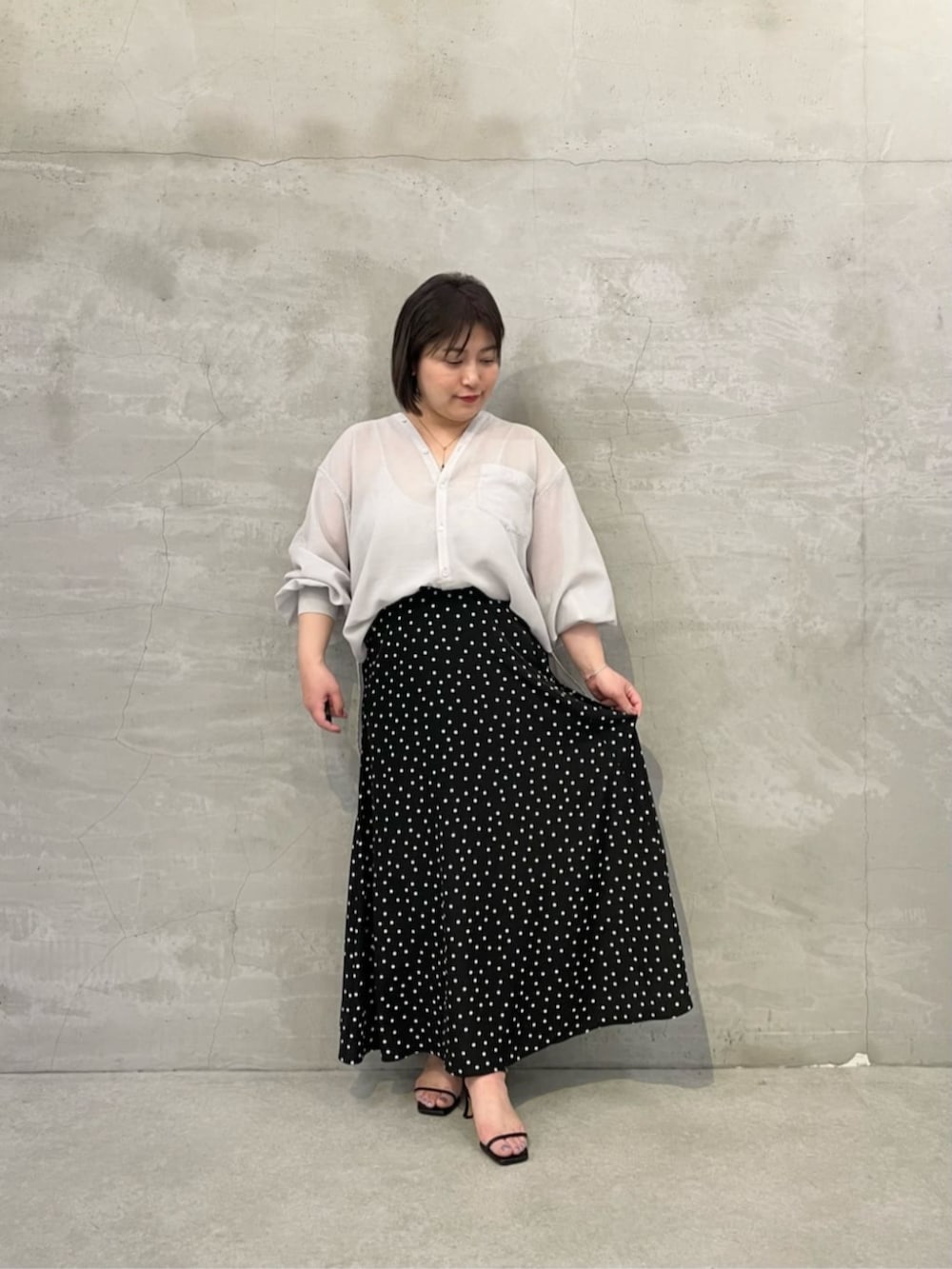 ブラック系のスカート、ホワイト系のトートバッグ、グレー系のシャツ/ブラウスを着用したレディースの冬コーディネートの5枚目の写真