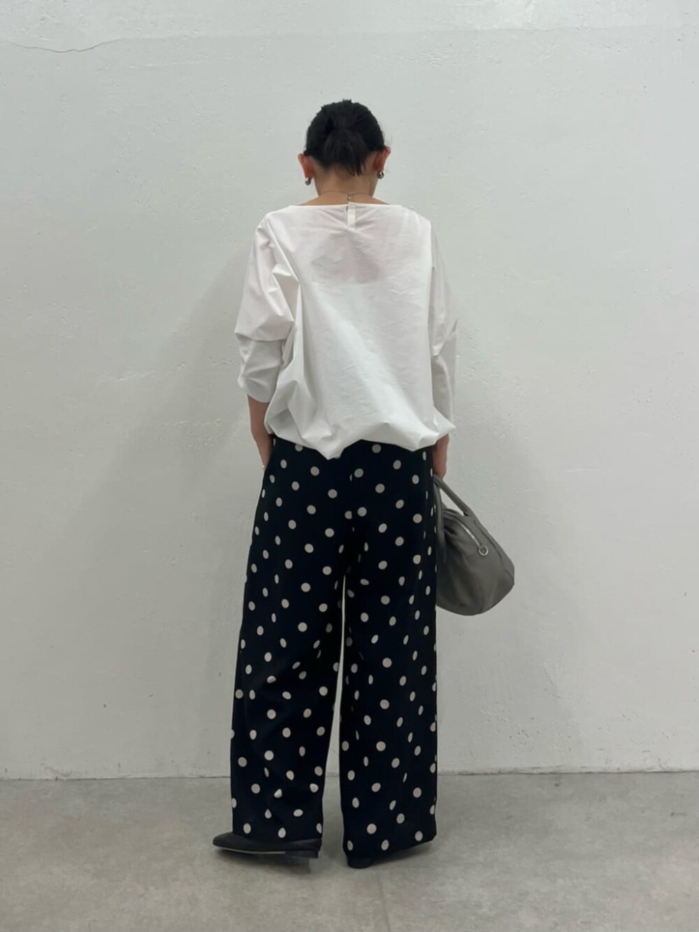 グレー系のボストンバッグ、ホワイト系のシャツ/ブラウス、ブラック系のその他パンツを着用したレディースの冬コーディネートの4枚目の写真