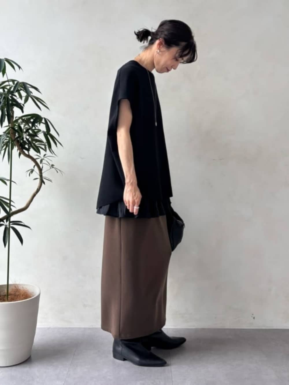 ブラック系のニット/セーター、ブラック系のタンクトップを着用したレディースの夏コーディネートの3枚目の写真