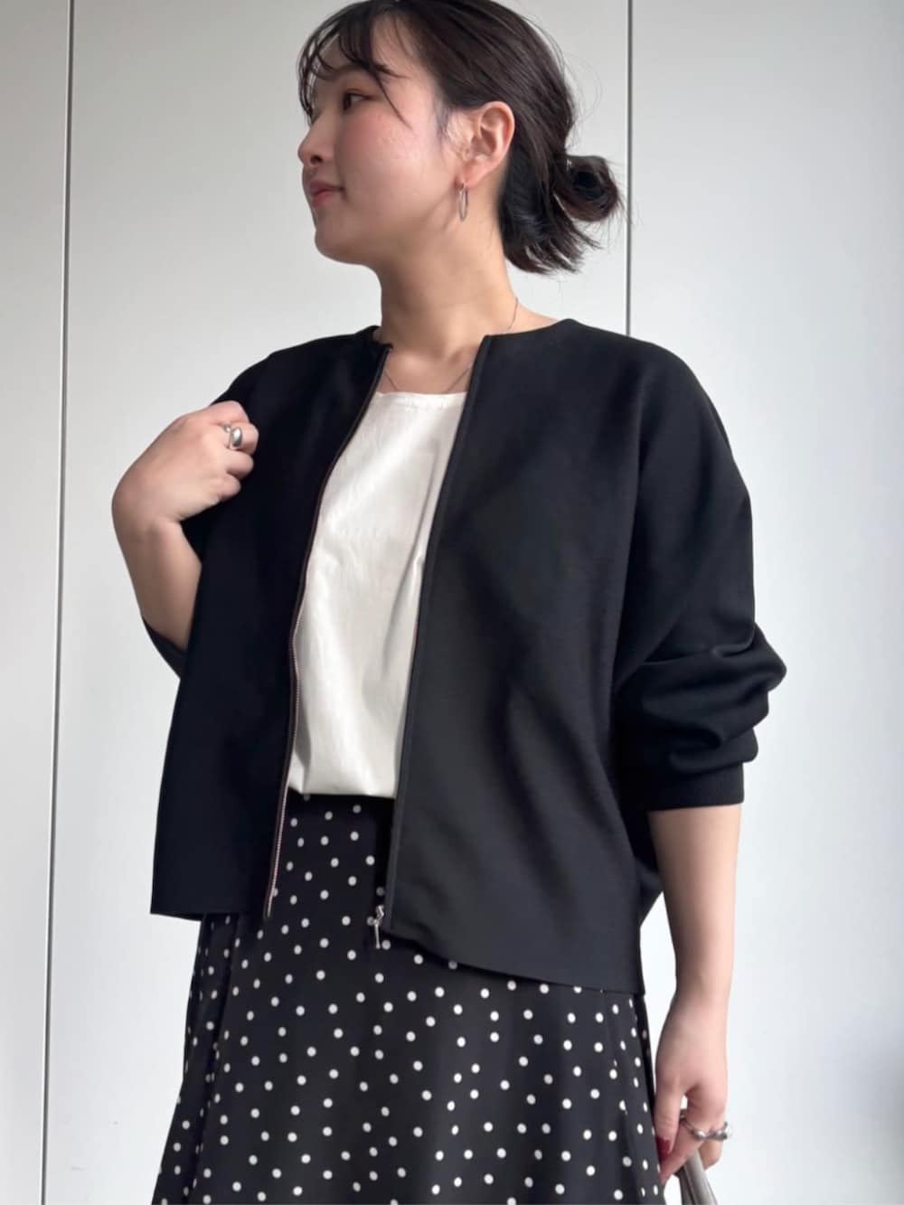 ブラック系のカーディガン/ボレロ、グレー系のボストンバッグ、ブラック系のスカートを着用したレディースの冬コーディネートの5枚目の写真