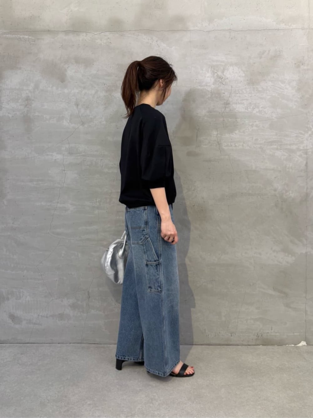 ブルー系のその他パンツ、ブラック系のTシャツ/カットソー、レッド系のチャームを着用したレディースの冬コーディネートの2枚目の写真