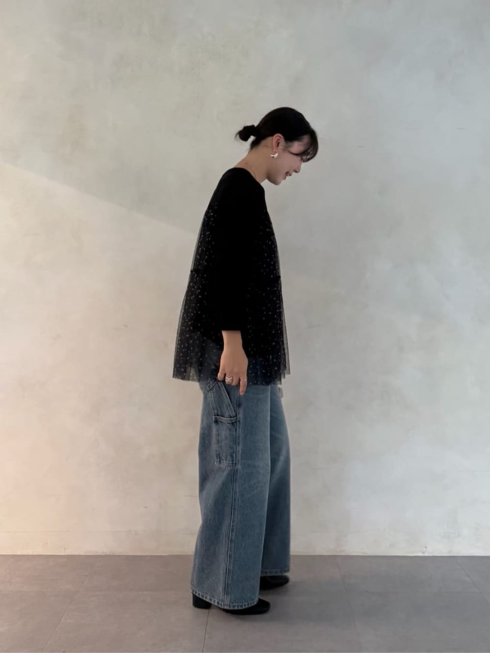 グレー系のボストンバッグ、ブラック系のTシャツ/カットソー、ブルー系のデニムパンツを着用したレディースの夏コーディネートの4枚目の写真