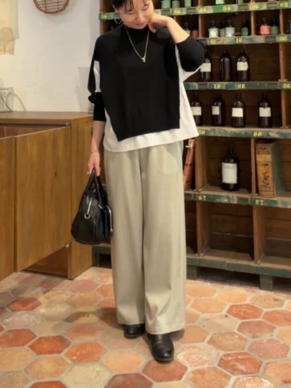 グレー系のその他パンツ、ブラック系のニット/セーターを着用したレディースの秋コーディネートの4枚目の写真