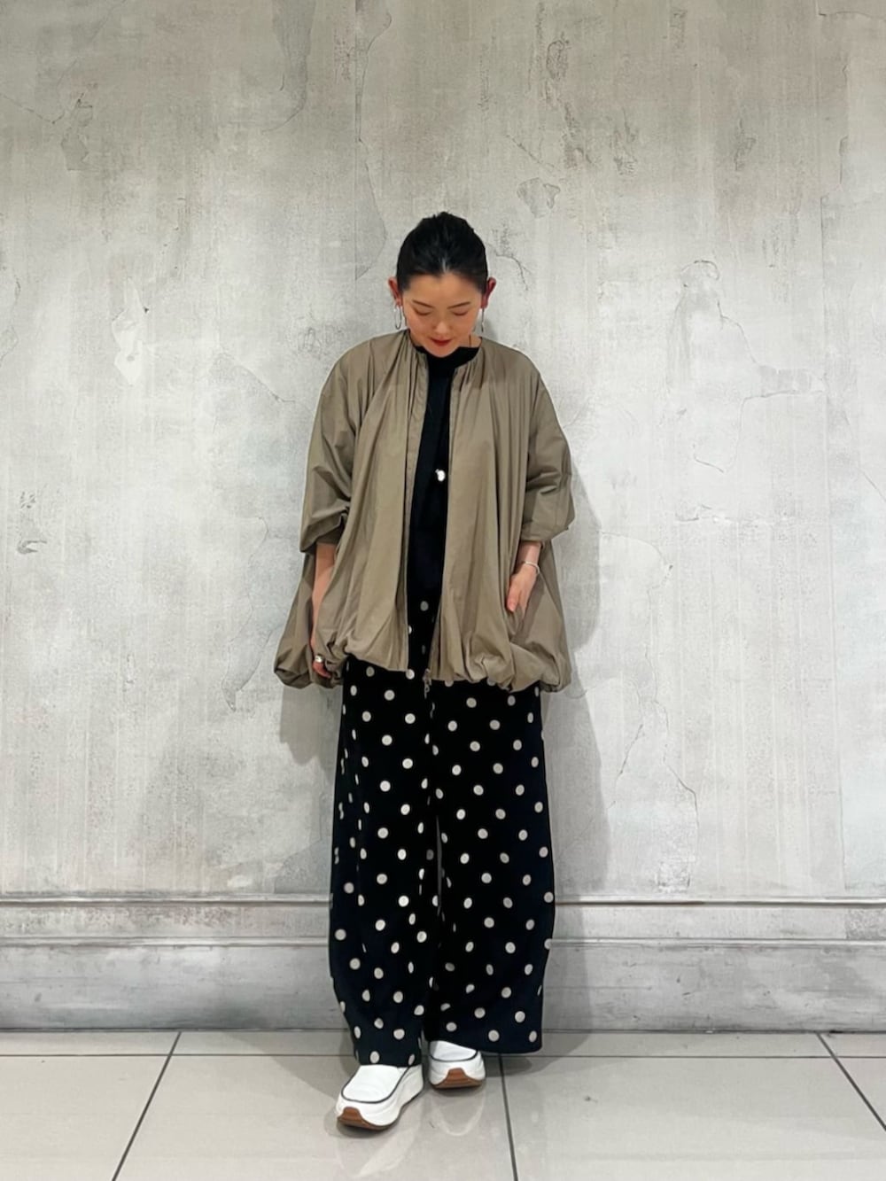 ブラック系のハンドバッグ、ブラック系のその他パンツ、ブラウン系のブルゾンを着用したレディースの春コーディネートの4枚目の写真