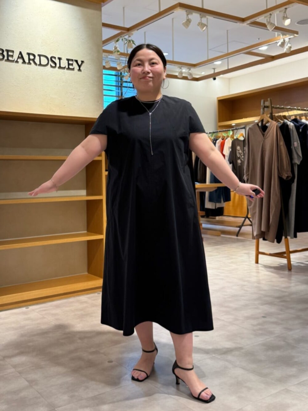 ブラック系のワンピースを着用したレディースの春コーディネートの2枚目の写真