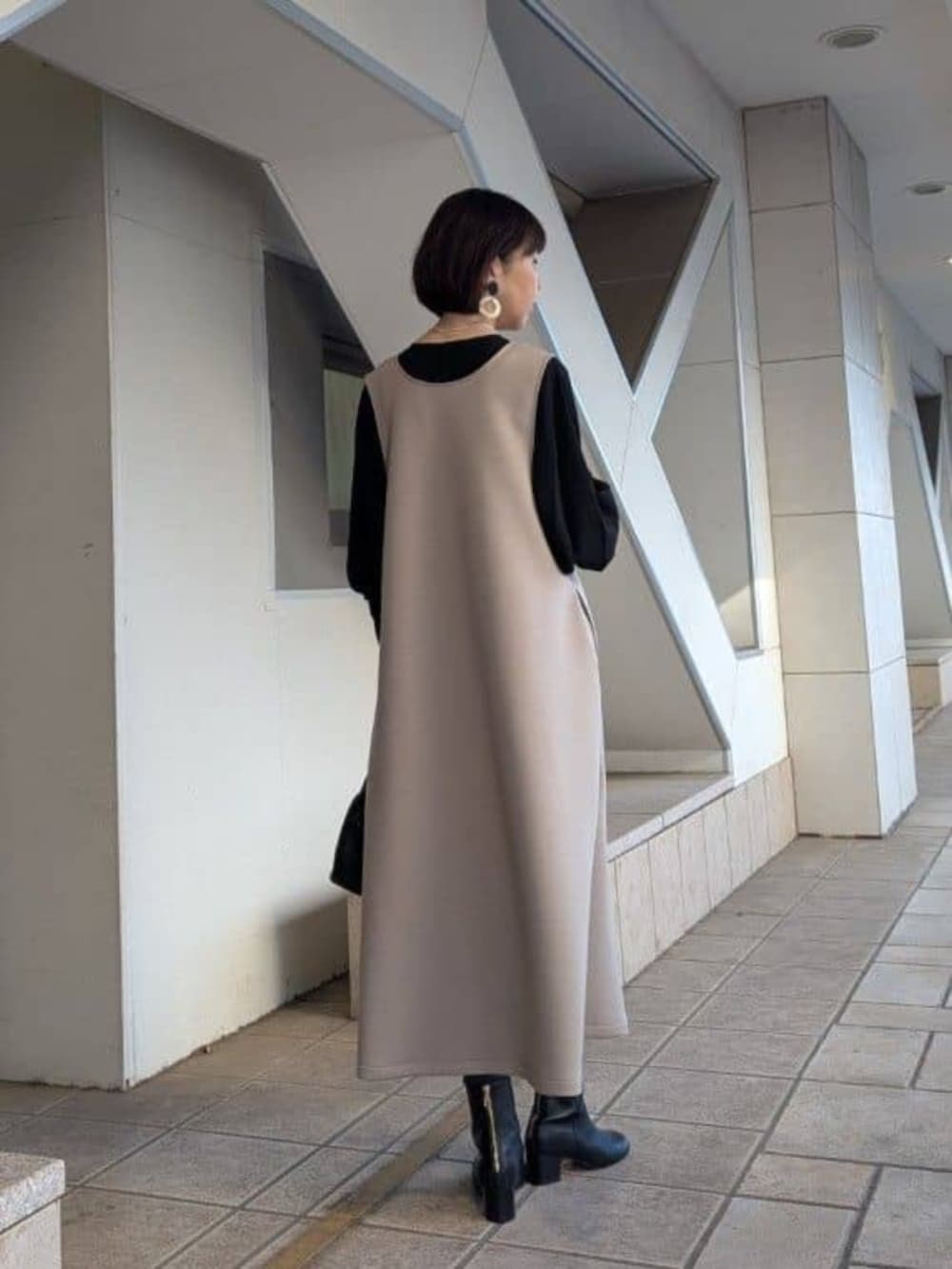 ブラック系のシャツ/ブラウス、ブラウン系のジャンパースカート、シルバー系のネックレスを着用したレディースの冬コーディネートの3枚目の写真