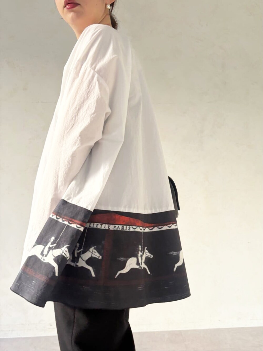 ブラック系のショルダーバッグ、ブラック系のその他パンツ、ホワイト系のシャツ/ブラウスを着用したレディースの秋コーディネートの2枚目の写真