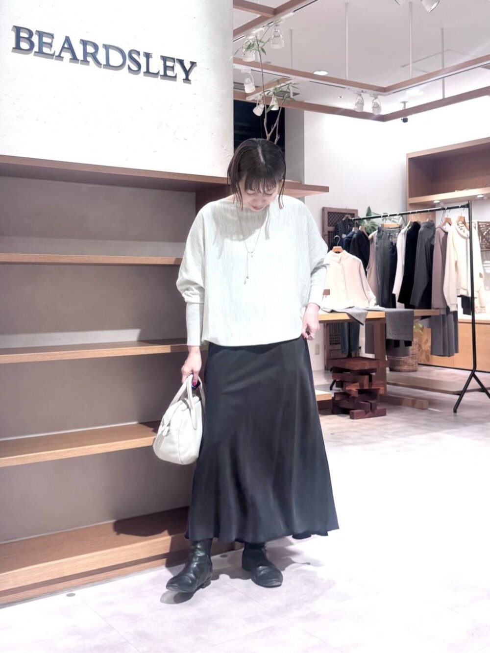 ブラック系のスカート、グレー系のボストンバッグ、グレー系のニット/セーターを着用したレディースの冬コーディネートの3枚目の写真