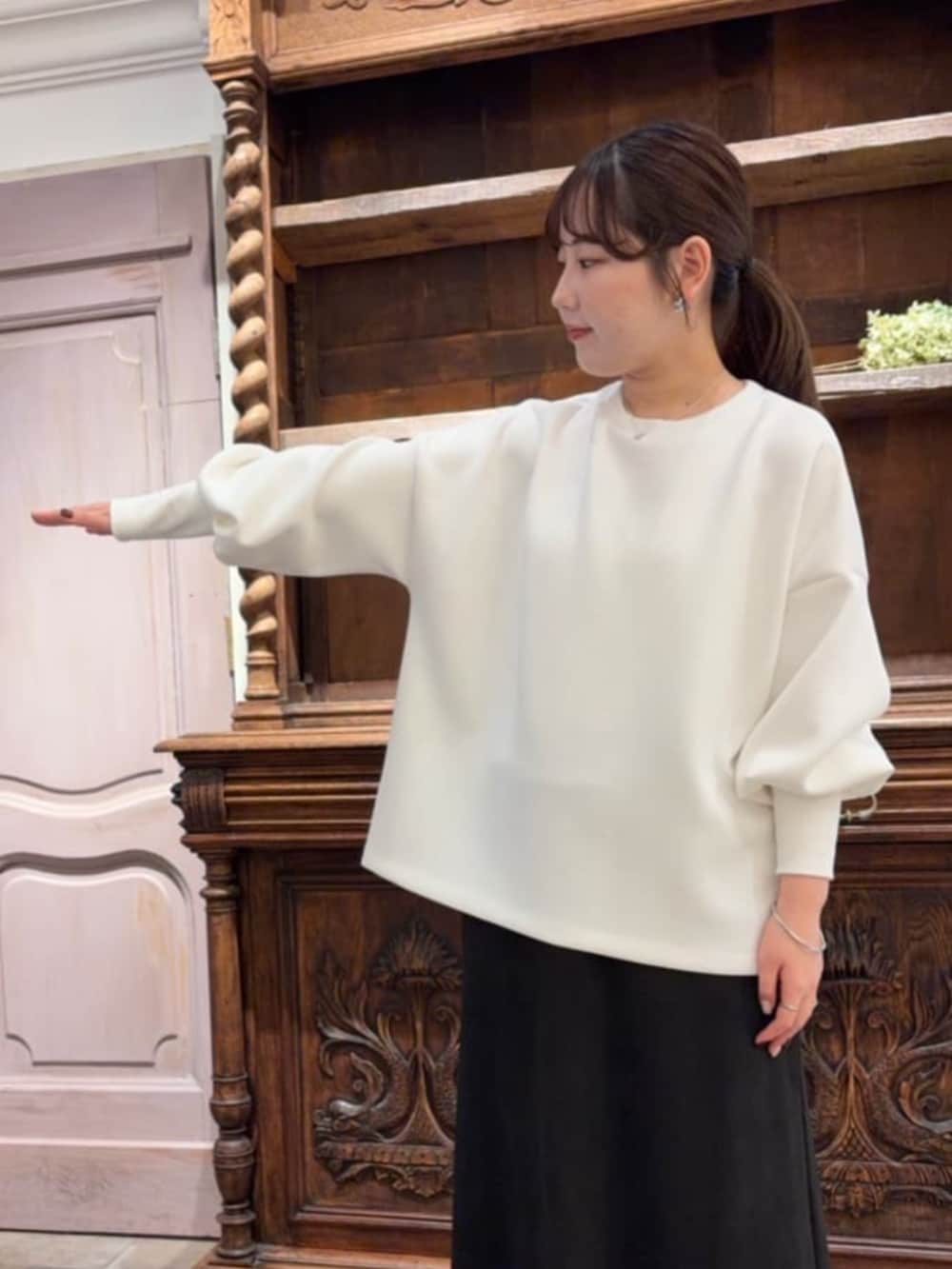 ブラック系のスカート、ブラック系のショルダーバッグ、ホワイト系のTシャツ/カットソーを着用したレディースの冬コーディネートの7枚目の写真