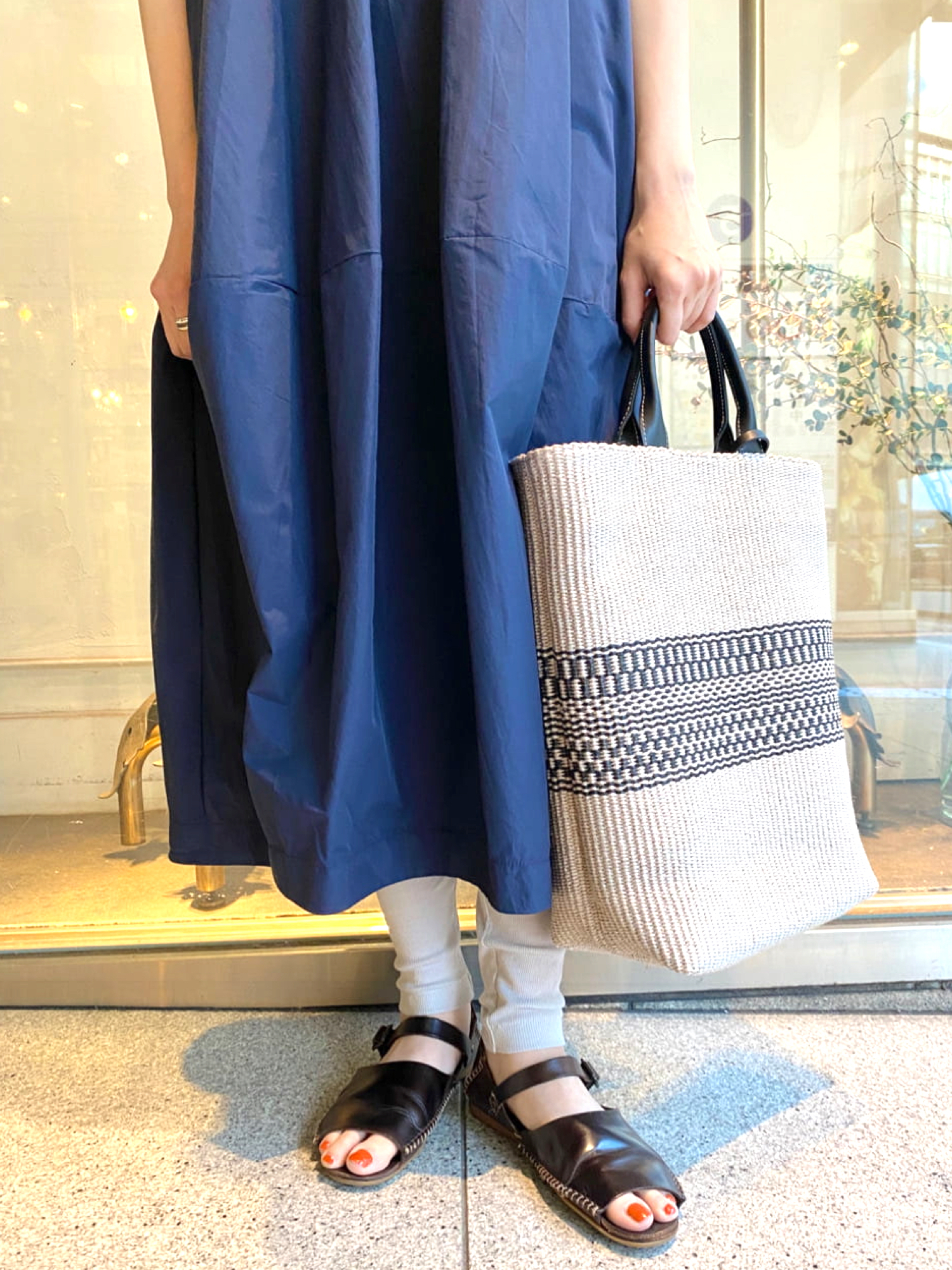 ブルー系のワンピース、グレー系のその他パンツ、ブラック系のトートバッグを着用したレディースの春コーディネートの4枚目の写真