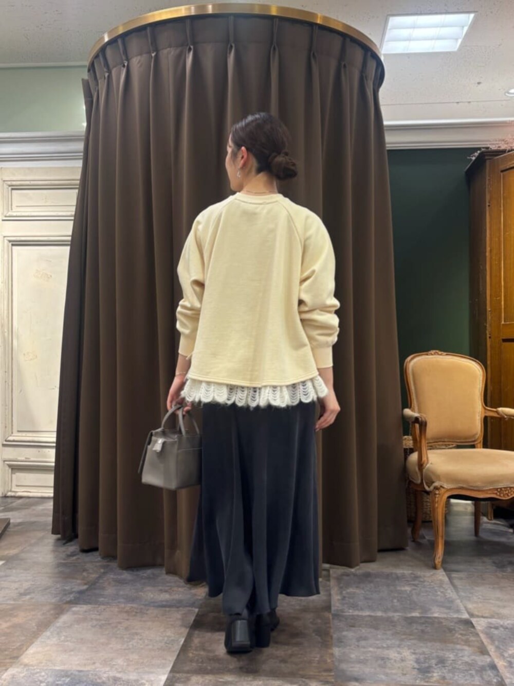 ブラック系のスカート、グレー系のハンドバッグ、ホワイト系のTシャツ/カットソーを着用したレディースの冬コーディネートの4枚目の写真