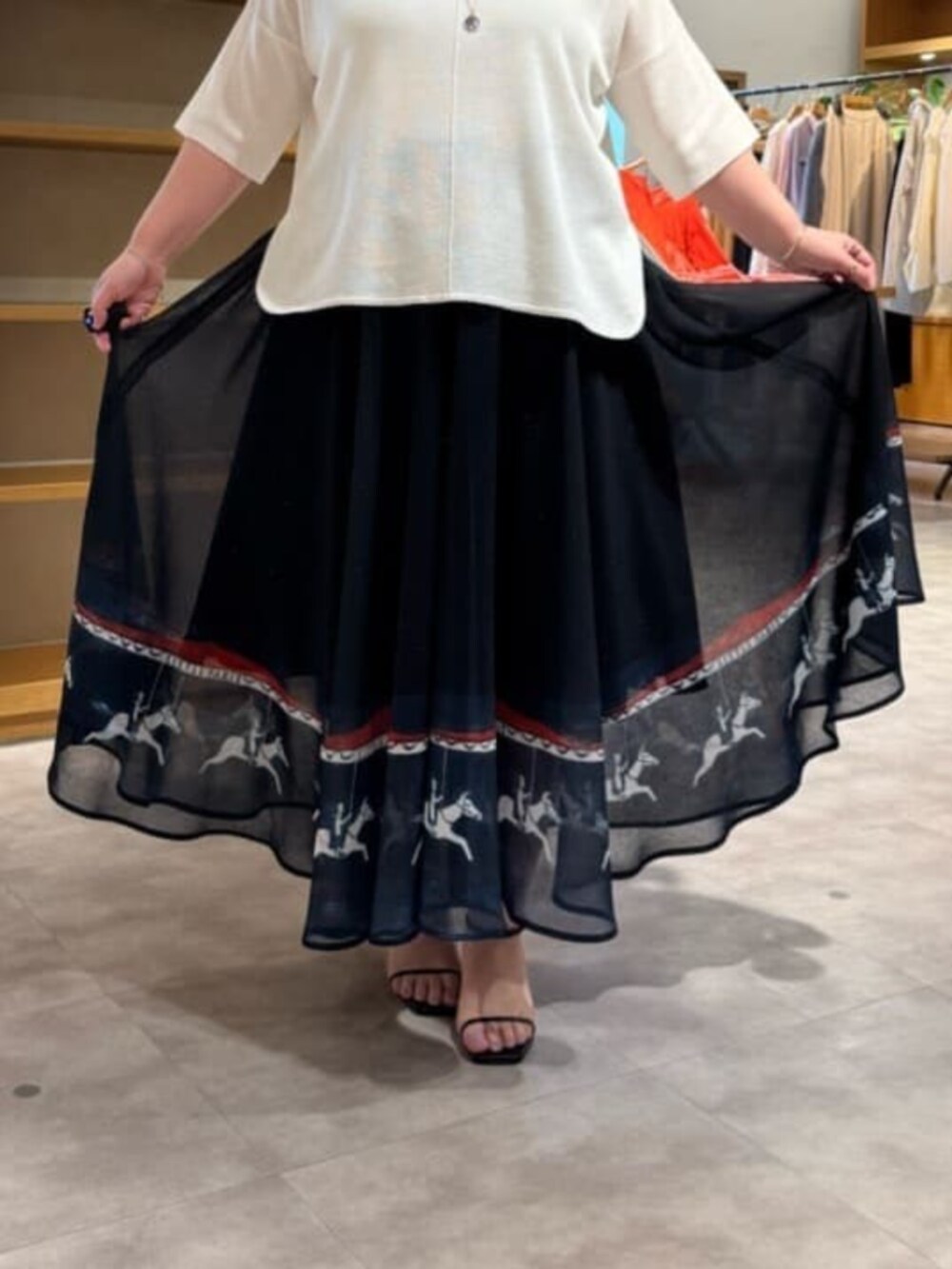 ホワイト系のトートバッグ、ブルー系のカーディガン/ボレロ、ブルー系のスカートを着用したレディースの春コーディネートの9枚目の写真