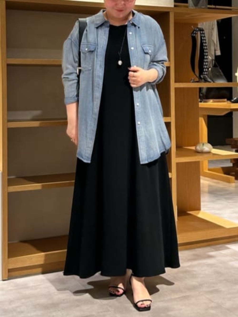 ブルー系のシャツ/ブラウス、ブラック系のワンピースを着用したレディースの春コーディネートの2枚目の写真