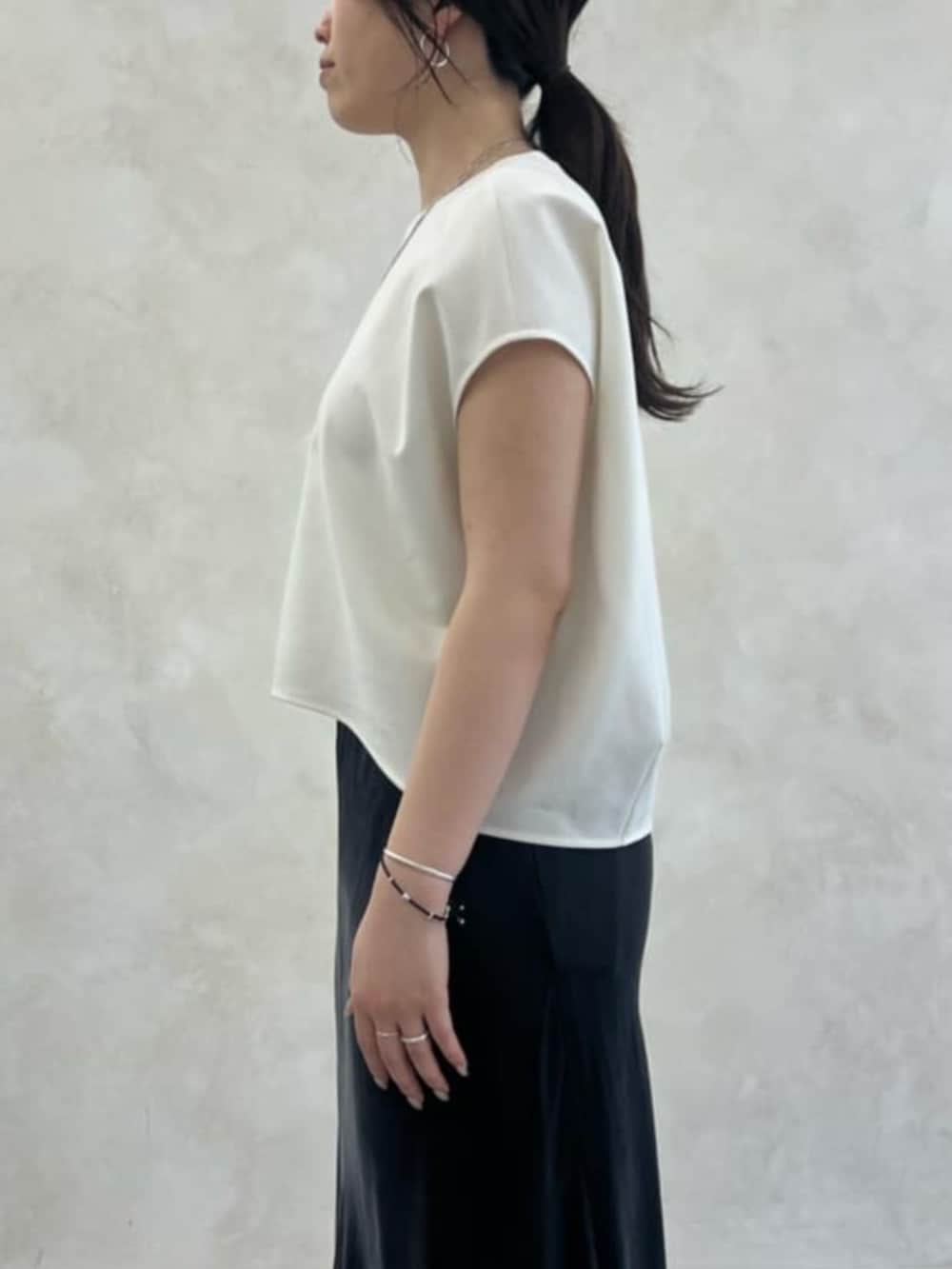 ブラック系のトートバッグ、ベージュ系のテーラードジャケット、ベージュ系のスカートを着用したレディースの春コーディネートの6枚目の写真