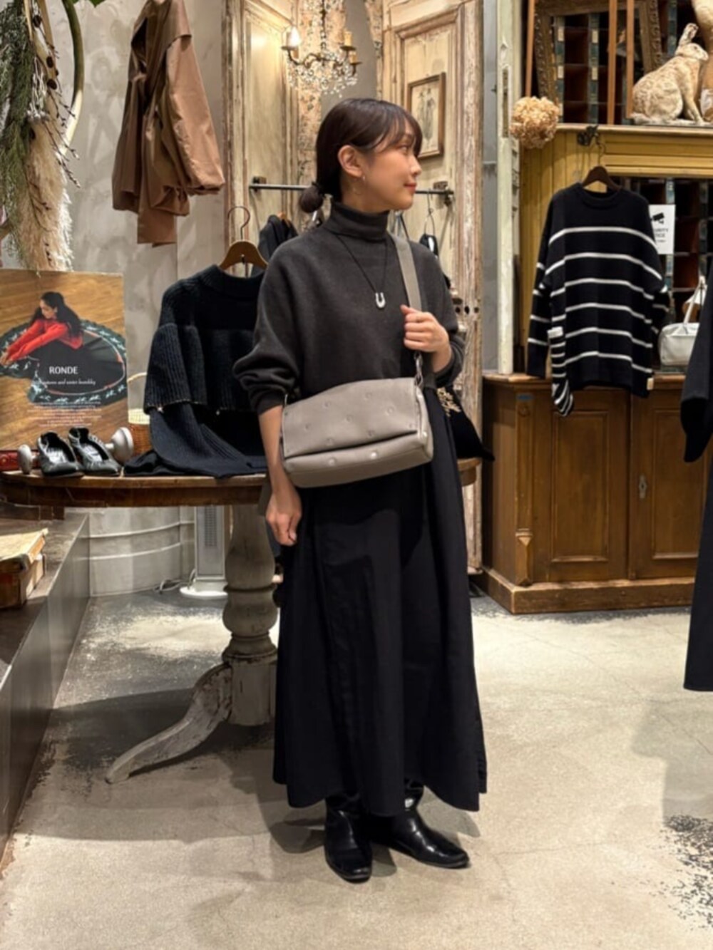 グレー系のワンピース、グレー系のショルダーバッグを着用したレディースの冬コーディネートの2枚目の写真