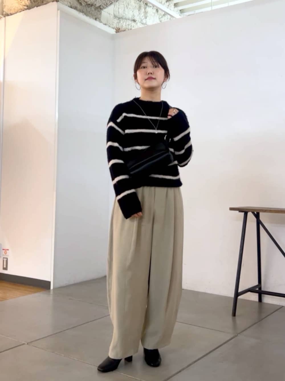 ブラック系のショルダーバッグ、グレー系のその他パンツ、ブラック系のニット/セーターを着用したレディースの秋コーディネートの2枚目の写真