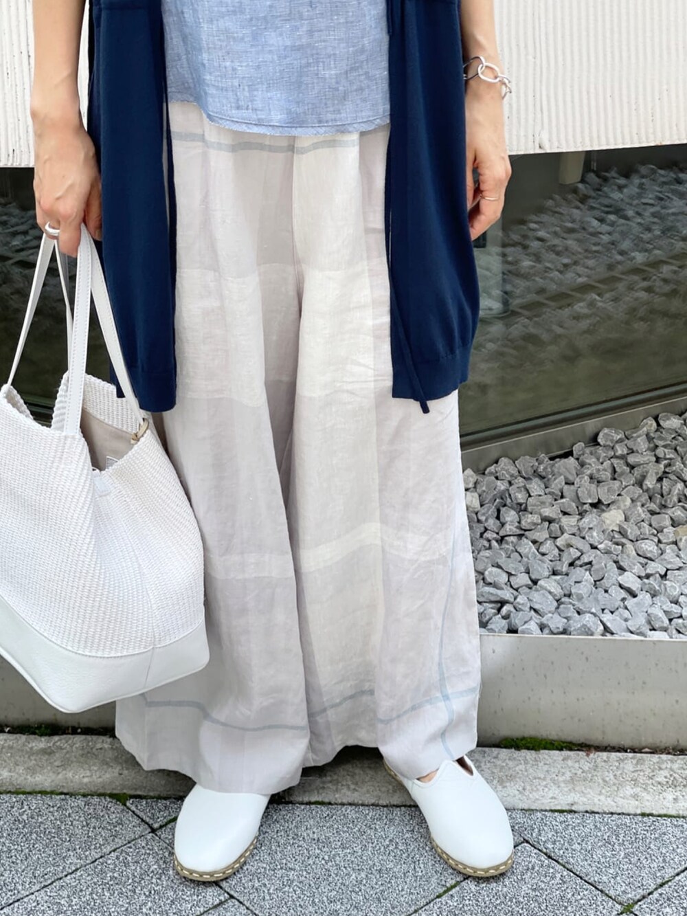 ホワイト系のトートバッグ、ホワイト系のタンクトップ、ホワイト系のその他シューズを着用したレディースの春コーディネートの3枚目の写真