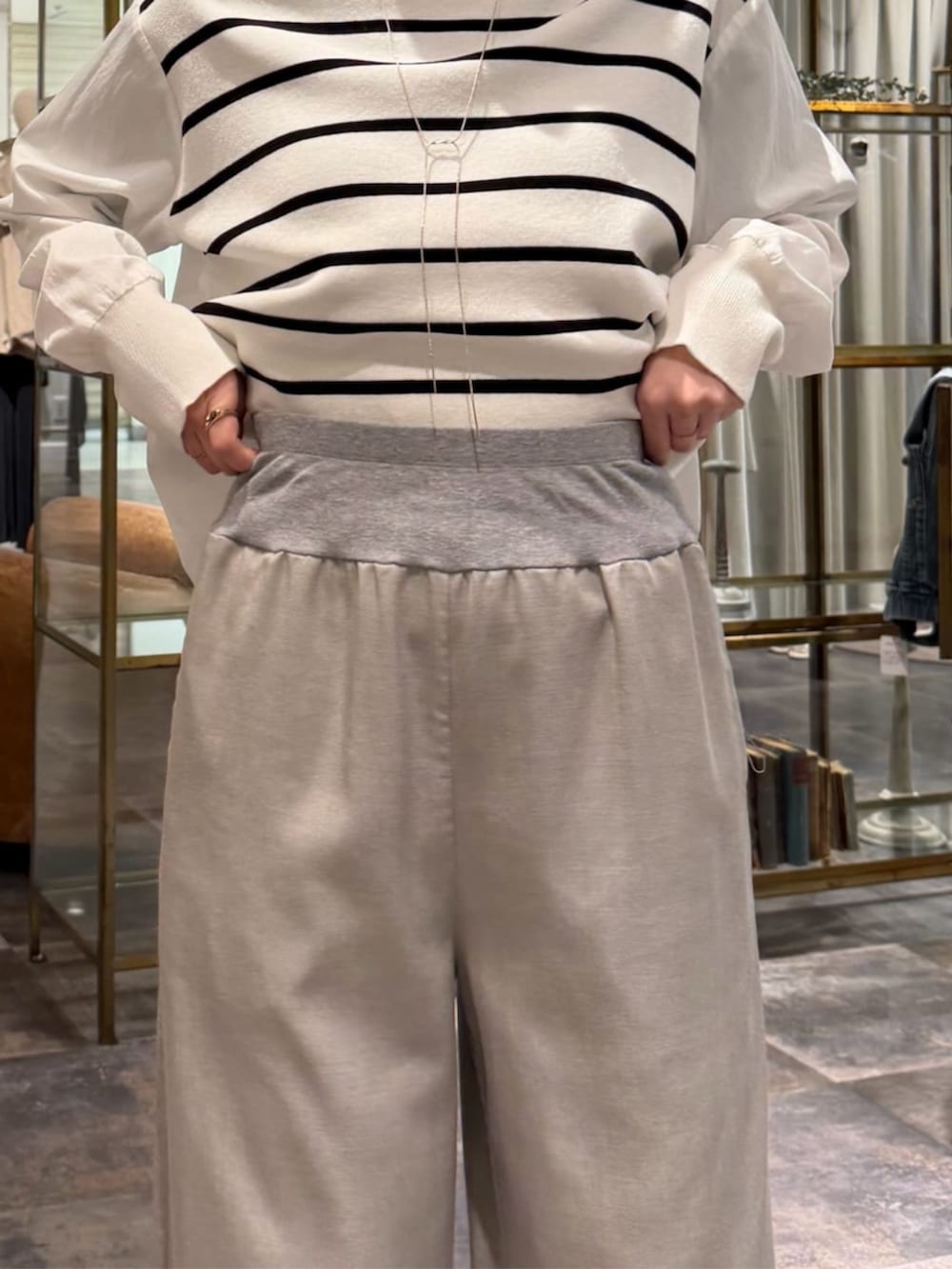 ブラック系のボストンバッグ、ホワイト系のニット/セーター、グレー系のその他パンツを着用したレディースの冬コーディネートの10枚目の写真