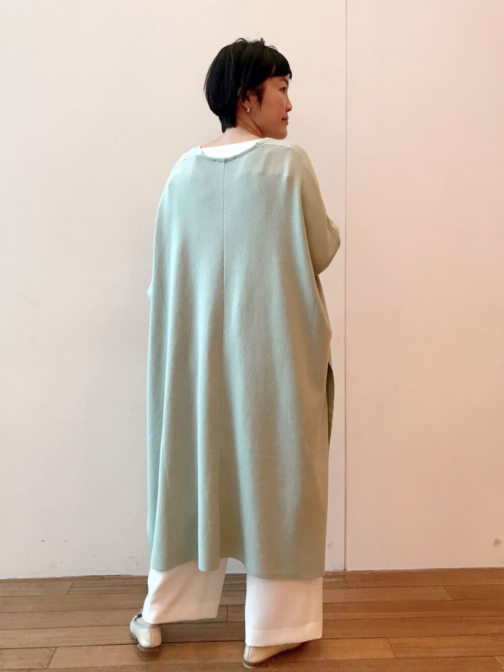 グリーン系のカーディガン/ボレロ、ホワイト系のTシャツ/カットソーを着用したレディースの冬コーディネートの3枚目の写真