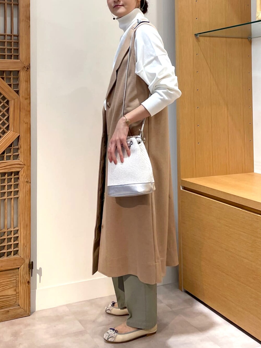 ホワイト系のトートバッグ、ベージュ系のワンピース、ホワイト系のニット/セーターを着用したレディースの春コーディネートの2枚目の写真