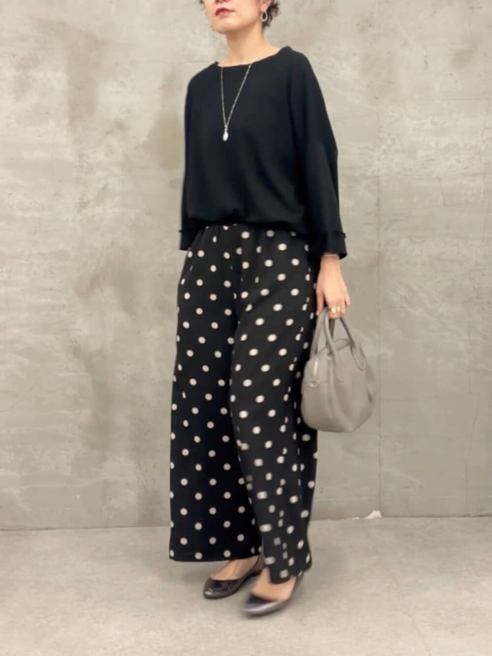 グレー系のボストンバッグ、ブラック系のTシャツ/カットソー、ブラック系のその他パンツを着用したレディースの春コーディネートの4枚目の写真