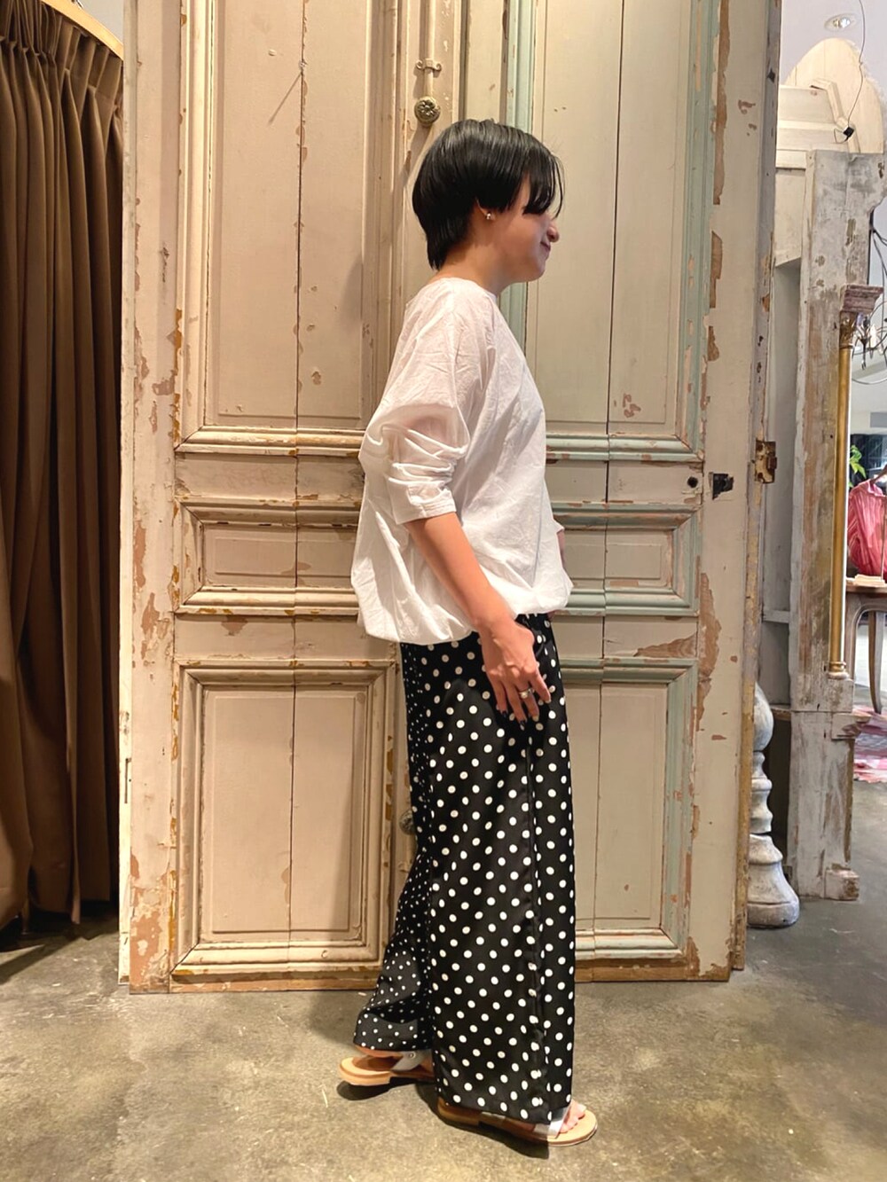 ブラック系のその他パンツ、ホワイト系のシャツ/ブラウス、シルバー系のサンダルを着用したレディースの春コーディネートの2枚目の写真