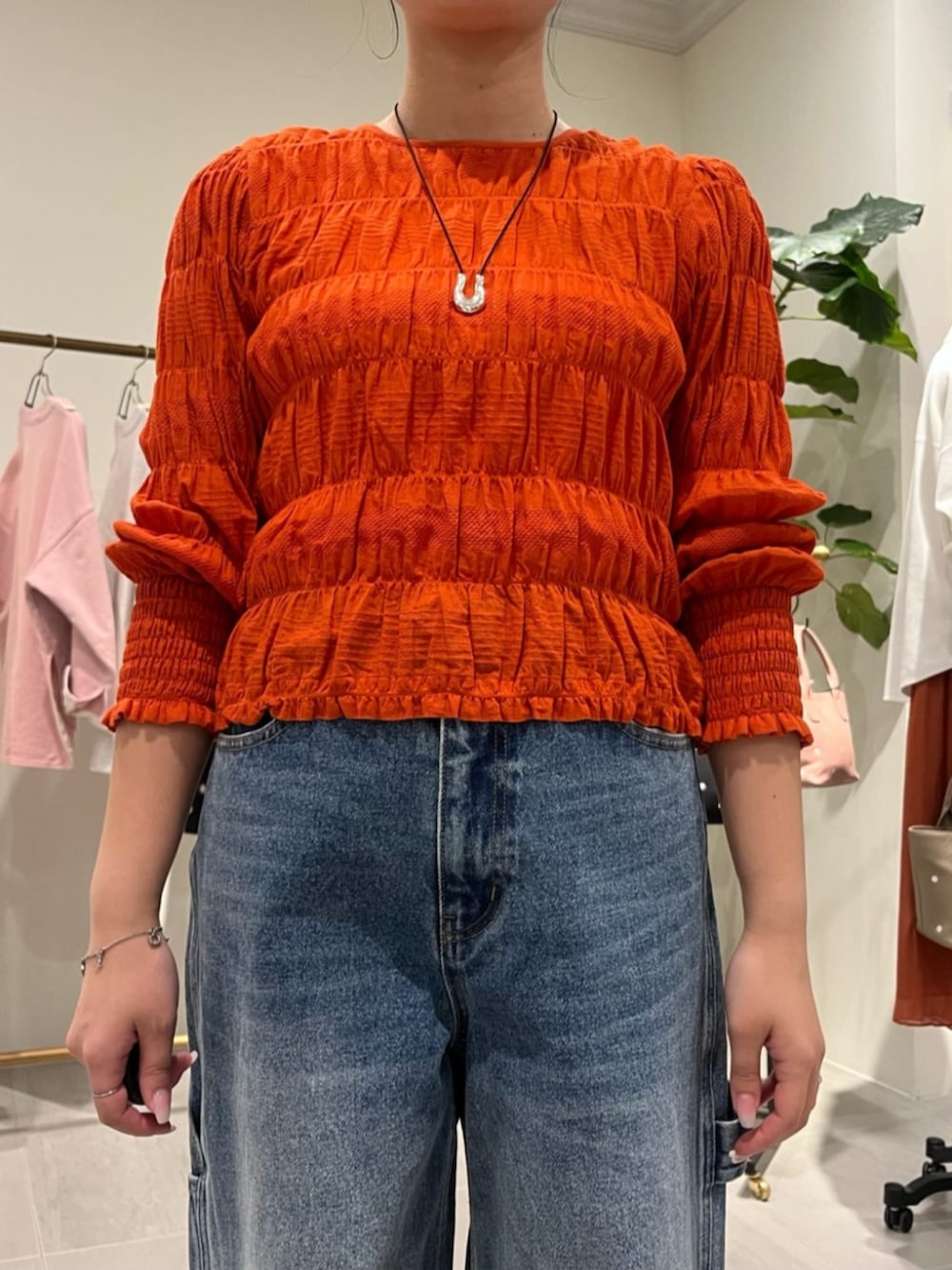 オレンジ系のシャツ/ブラウス、ブラウン系のトートバッグ、ブルー系のその他パンツを着用したレディースの春コーディネートの4枚目の写真