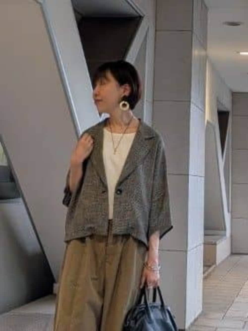 ブラック系のボストンバッグ、イエロー系のその他パンツ、ベージュ系のテーラードジャケットを着用したレディースの夏コーディネートの6枚目の写真