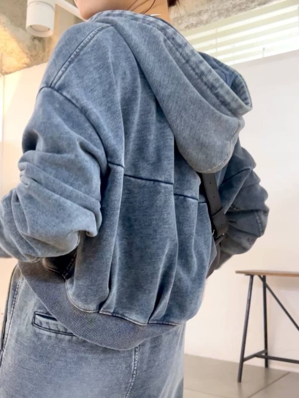 ブラック系のショルダーバッグ、ブルー系のその他パンツ、ブルー系のパーカーを着用したレディースの秋コーディネートの3枚目の写真