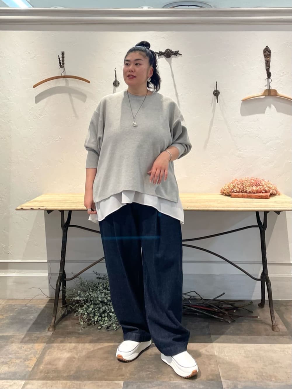 ホワイト系のスニーカー、ホワイト系のシャツ/ブラウス、グレー系のニット/セーターを着用したレディースの冬コーディネートの4枚目の写真