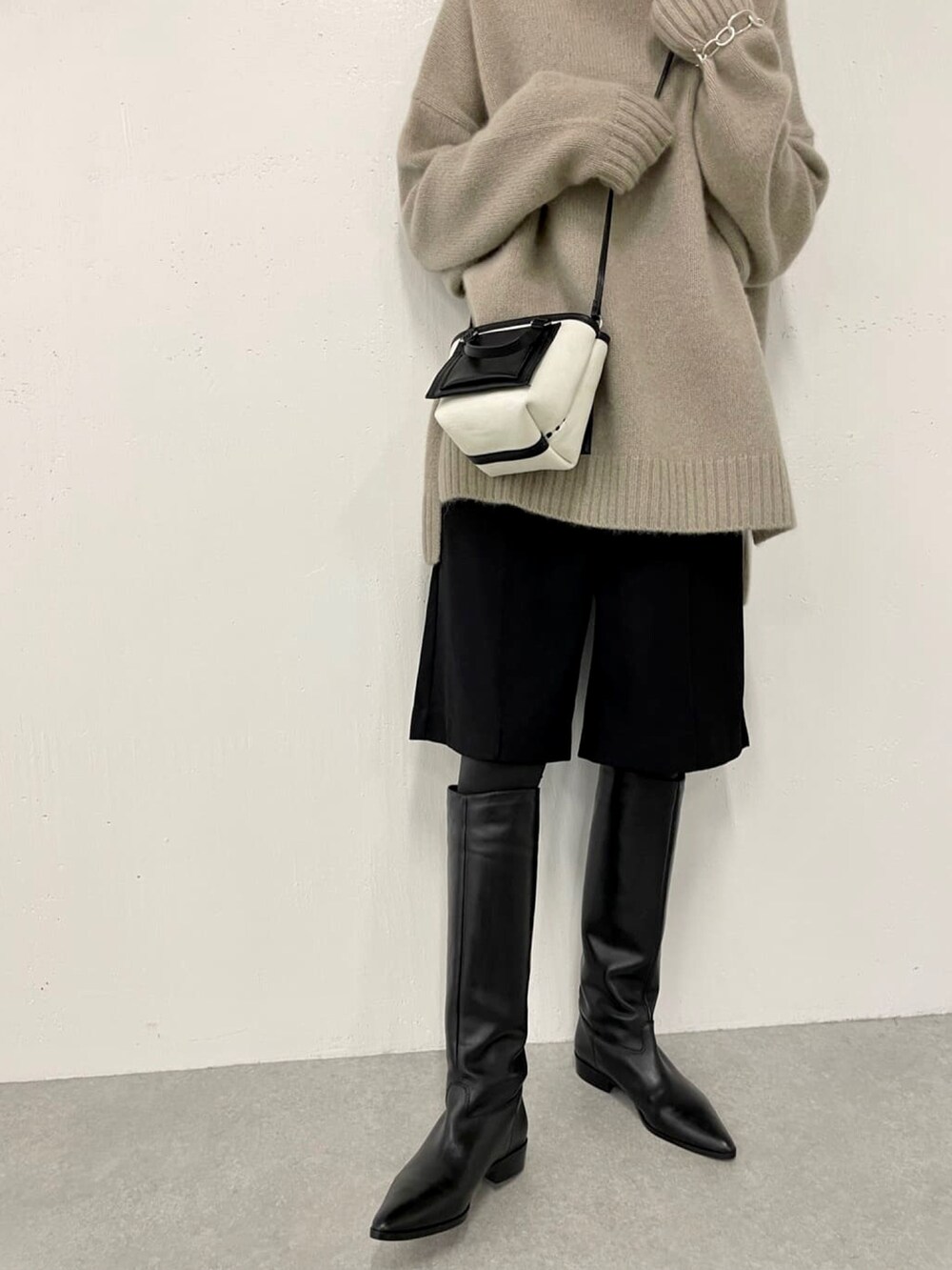 ブラック系のその他パンツ、ブラック系のノーカラーコート、グリーン系のニット/セーターを着用したレディースの秋コーディネートの4枚目の写真