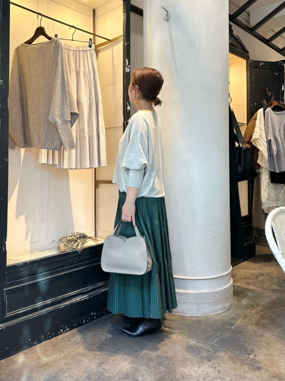 グリーン系のスカート、グレー系のニット/セーター、ブラック系のダウンジャケット/コートを着用したレディースの冬コーディネートの8枚目の写真