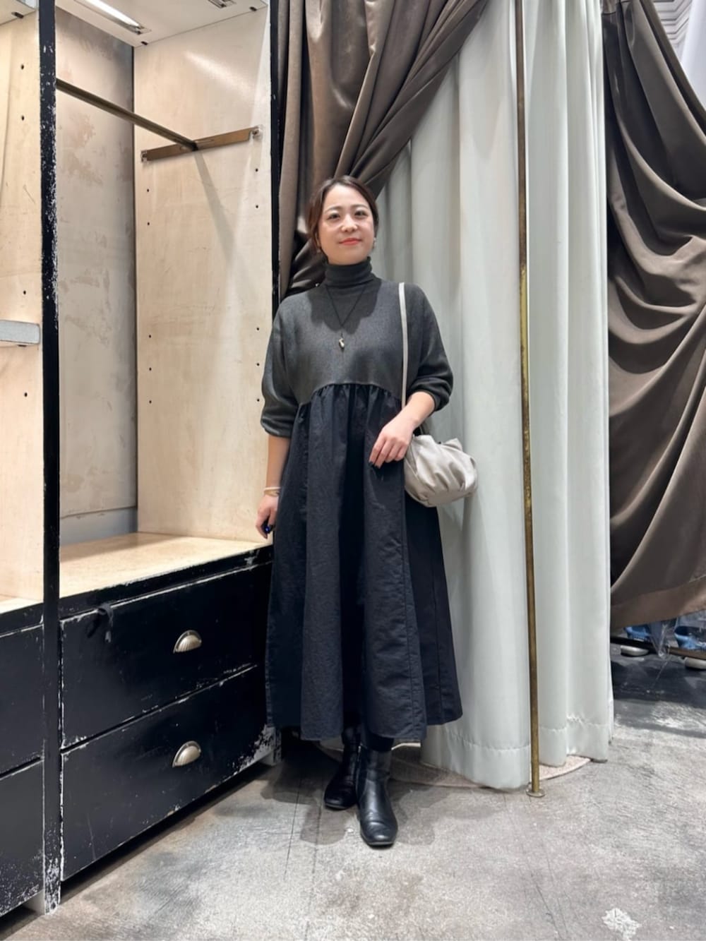 グレー系のワンピース、ブルー系のノーカラーコートを着用したレディースの冬コーディネートの5枚目の写真