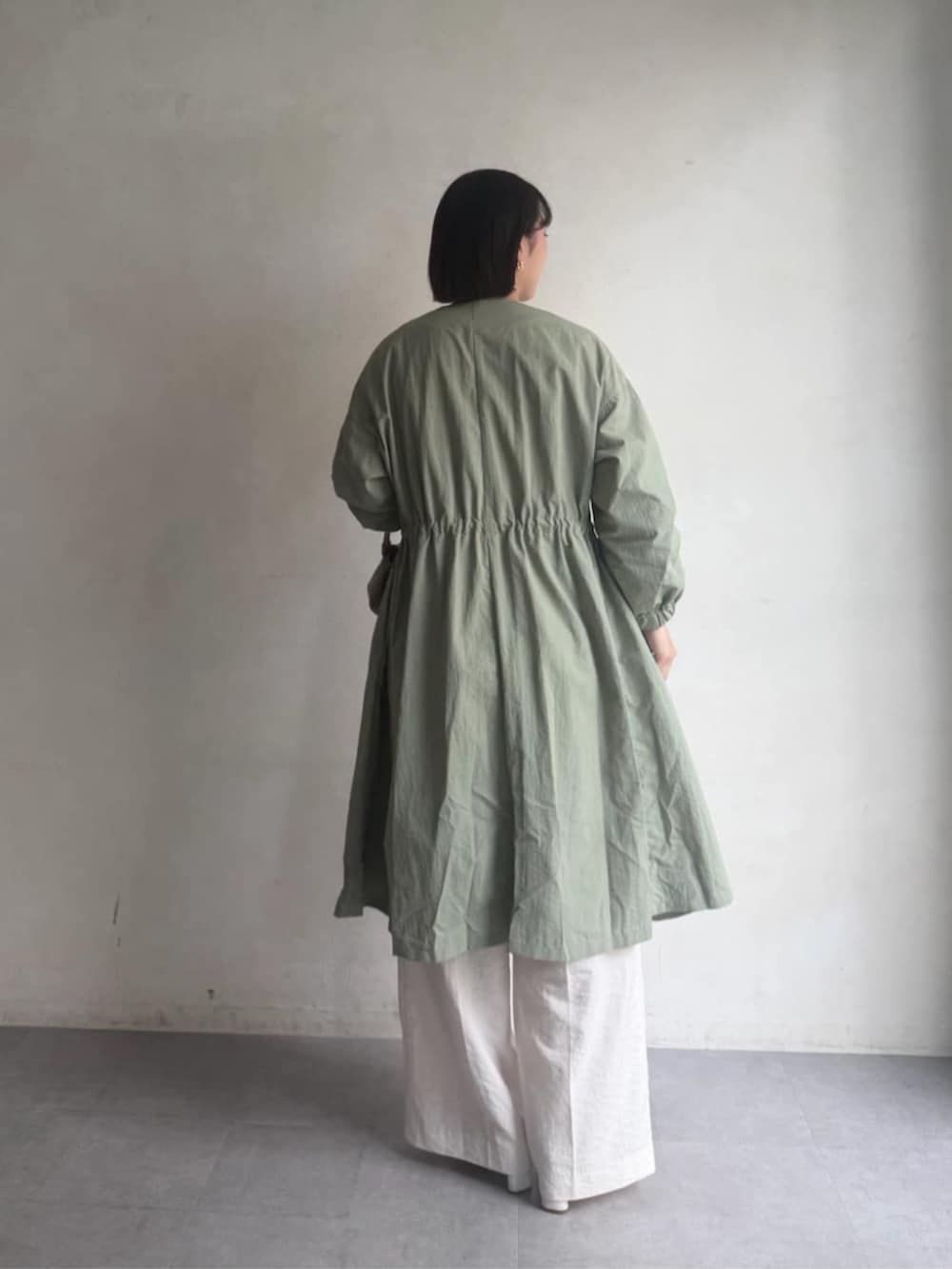 グリーン系のその他アウター、ホワイト系のその他パンツ、ホワイト系のTシャツ/カットソーを着用したレディースの冬コーディネートの4枚目の写真