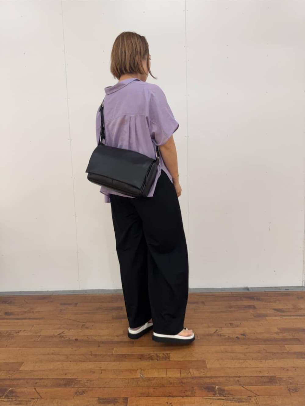 ブラック系のその他パンツ、ホワイト系のサンダル、ブラック系のショルダーバッグを着用したレディースの春コーディネートの2枚目の写真