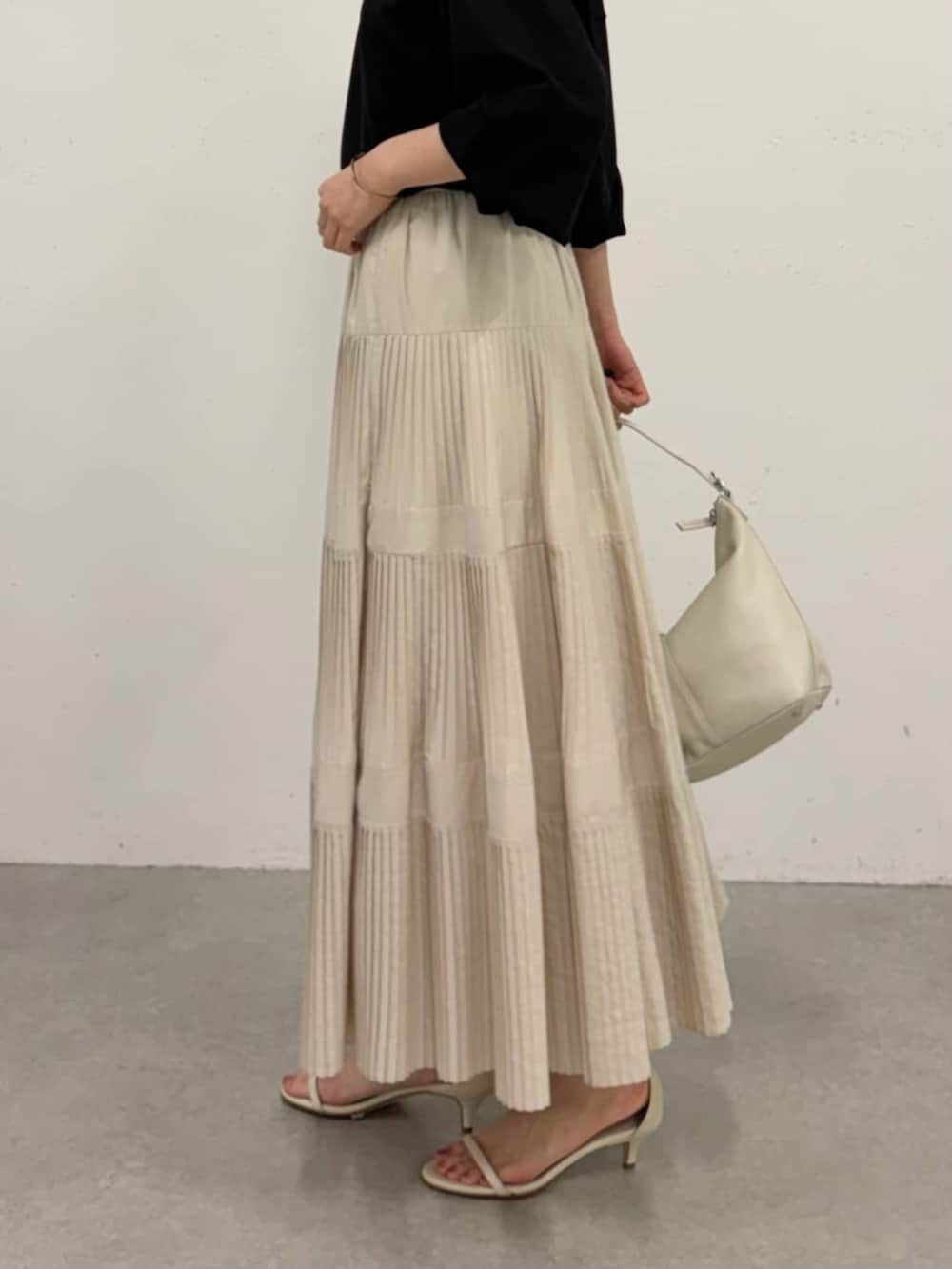 ホワイト系のスカート、ブラック系のシャツ/ブラウスを着用したレディースの春コーディネートの8枚目の写真