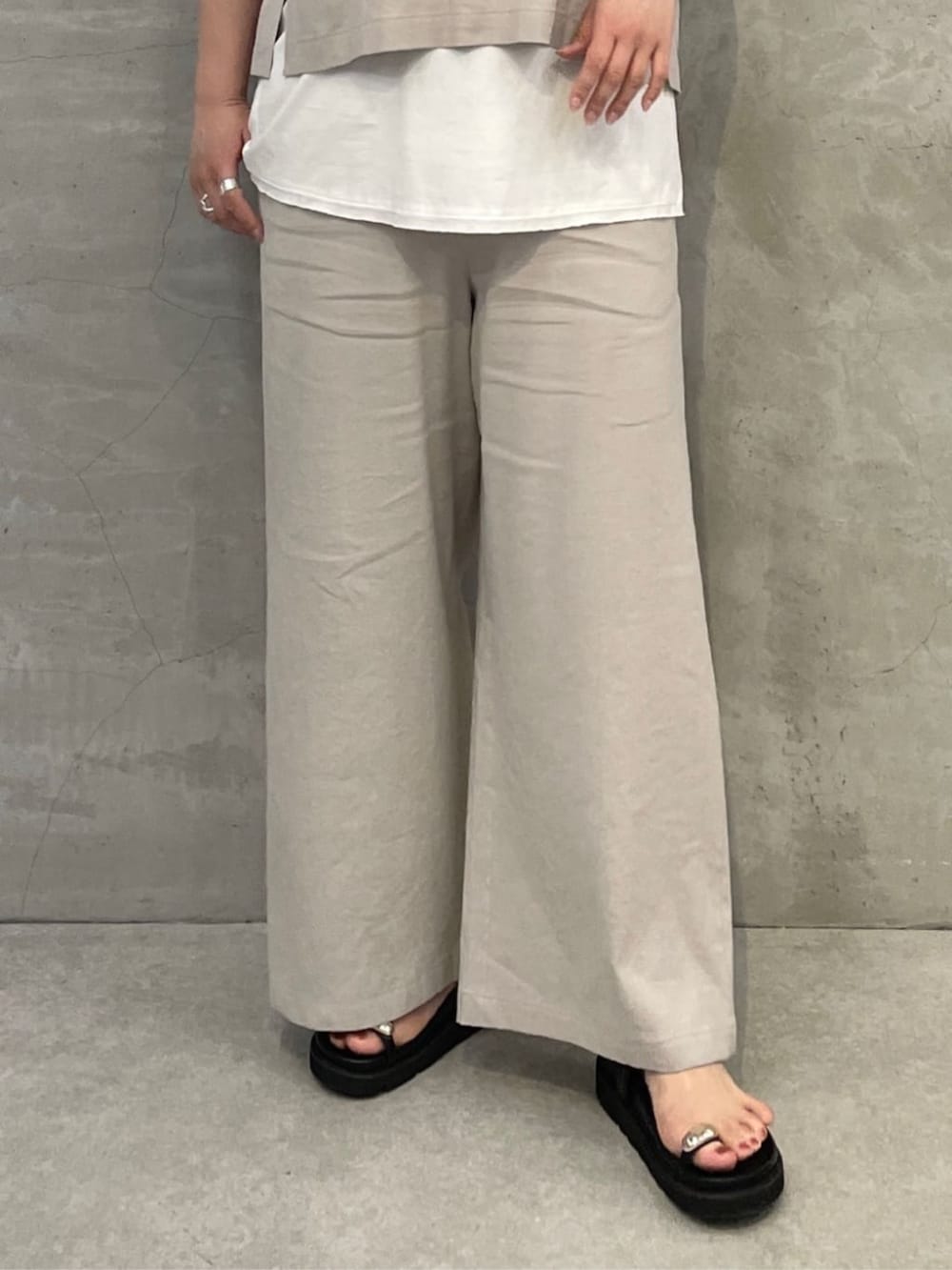 ホワイト系のタンクトップ、ブラック系のショルダーバッグ、ブラック系のサンダルを着用したレディースの春コーディネートの7枚目の写真