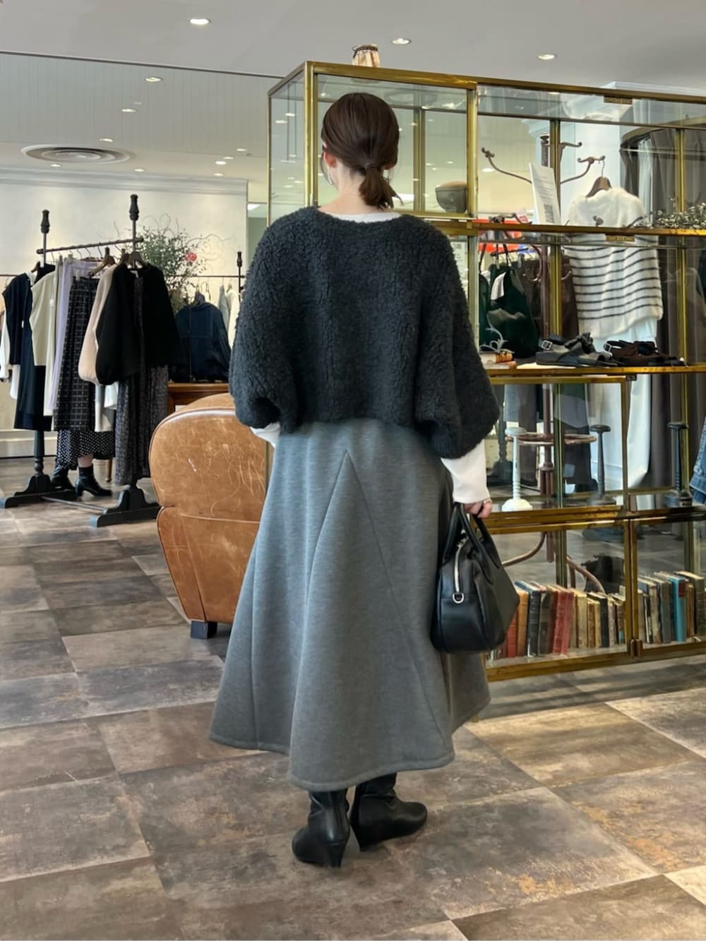 グレー系のニット/セーター、グレー系のスカートを着用したレディースの冬コーディネートの3枚目の写真