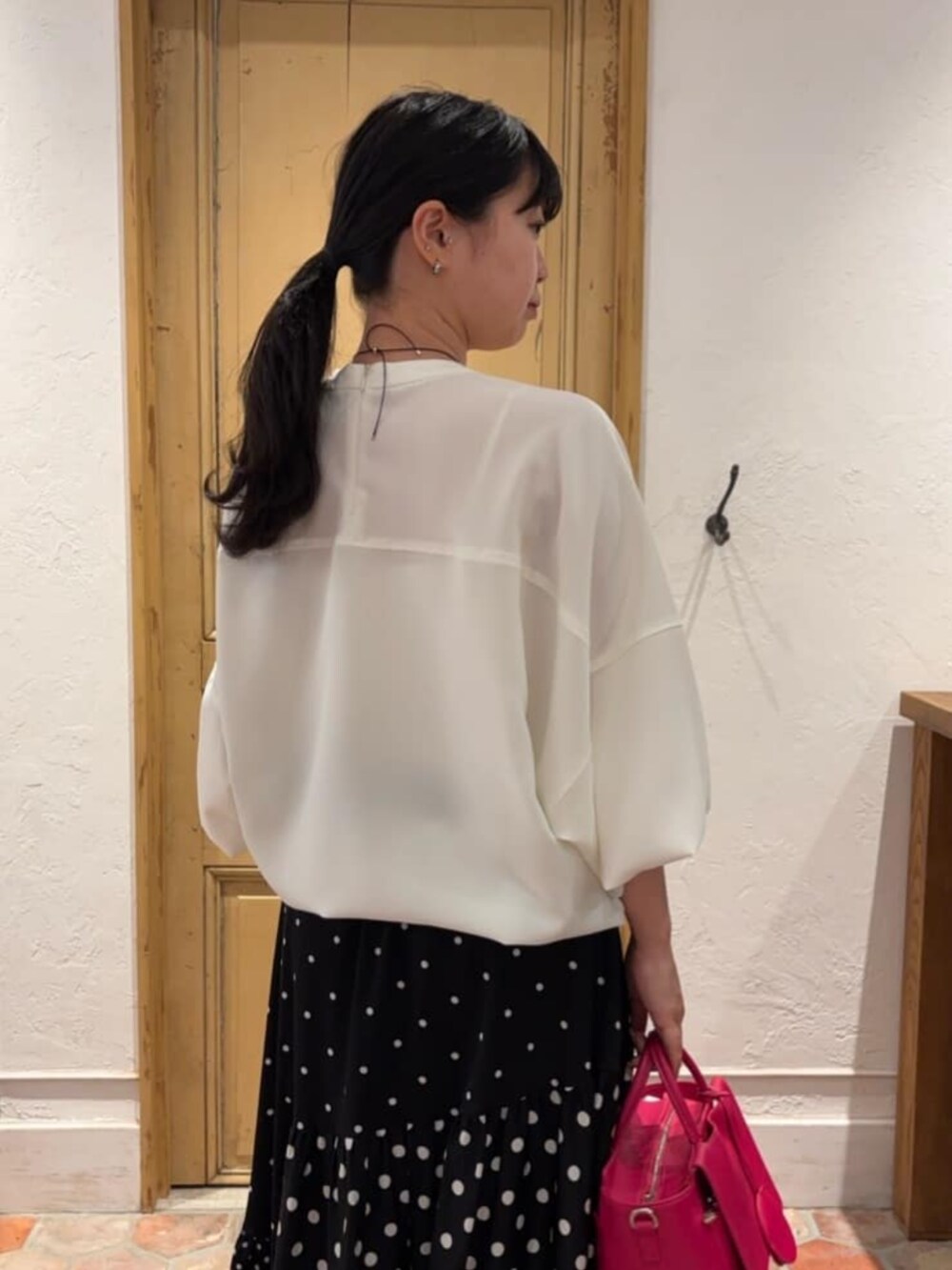 ブラック系のスカート、ピンク系のハンドバッグ、ホワイト系のシャツ/ブラウスを着用したレディースの冬コーディネートの7枚目の写真