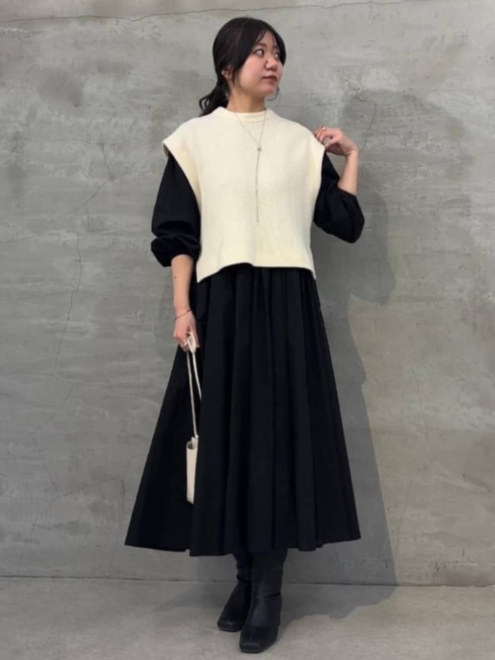 ブラック系のワンピース、ホワイト系のシャツ/ブラウス、ホワイト系のショルダーバッグを着用したレディースの冬コーディネートの2枚目の写真