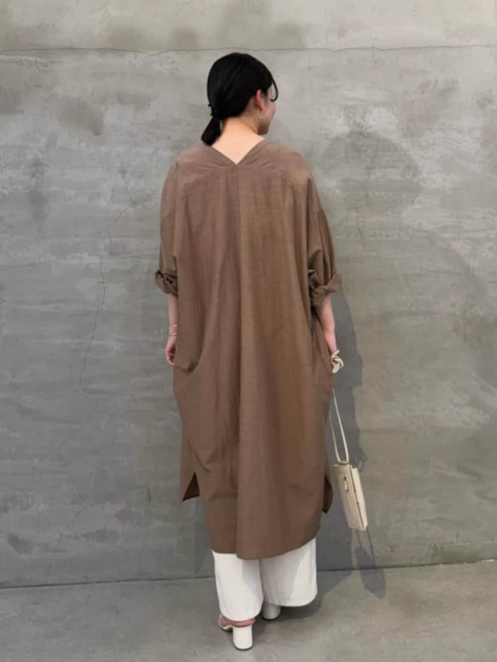 ホワイト系のショルダーバッグ、ホワイト系のシャツ/ブラウス、ベージュ系のワンピースを着用したレディースの冬コーディネートの3枚目の写真