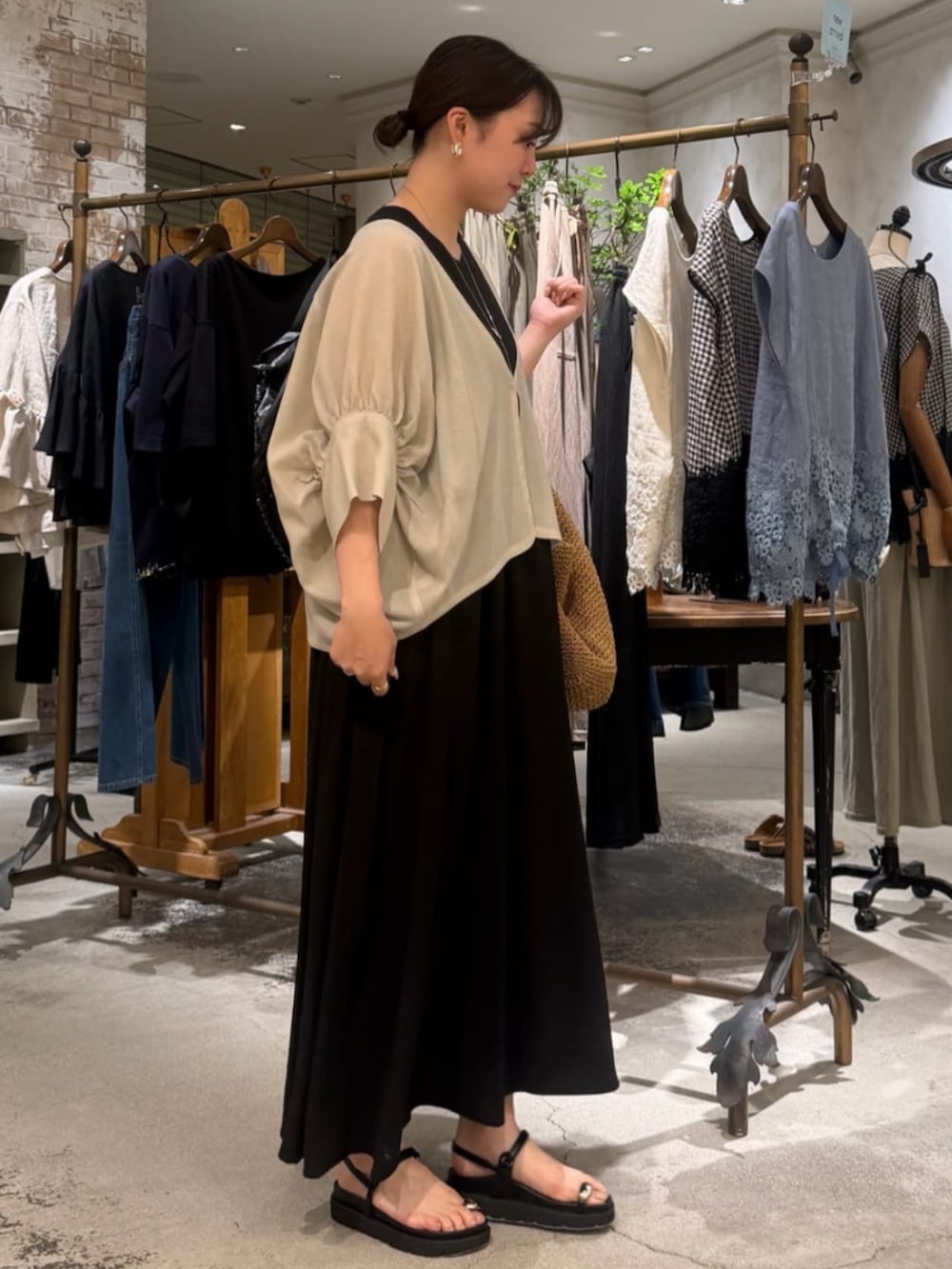 ブラック系のサンダル、ブラック系のワンピース、ベージュ系のベストを着用したレディースの夏コーディネートの4枚目の写真