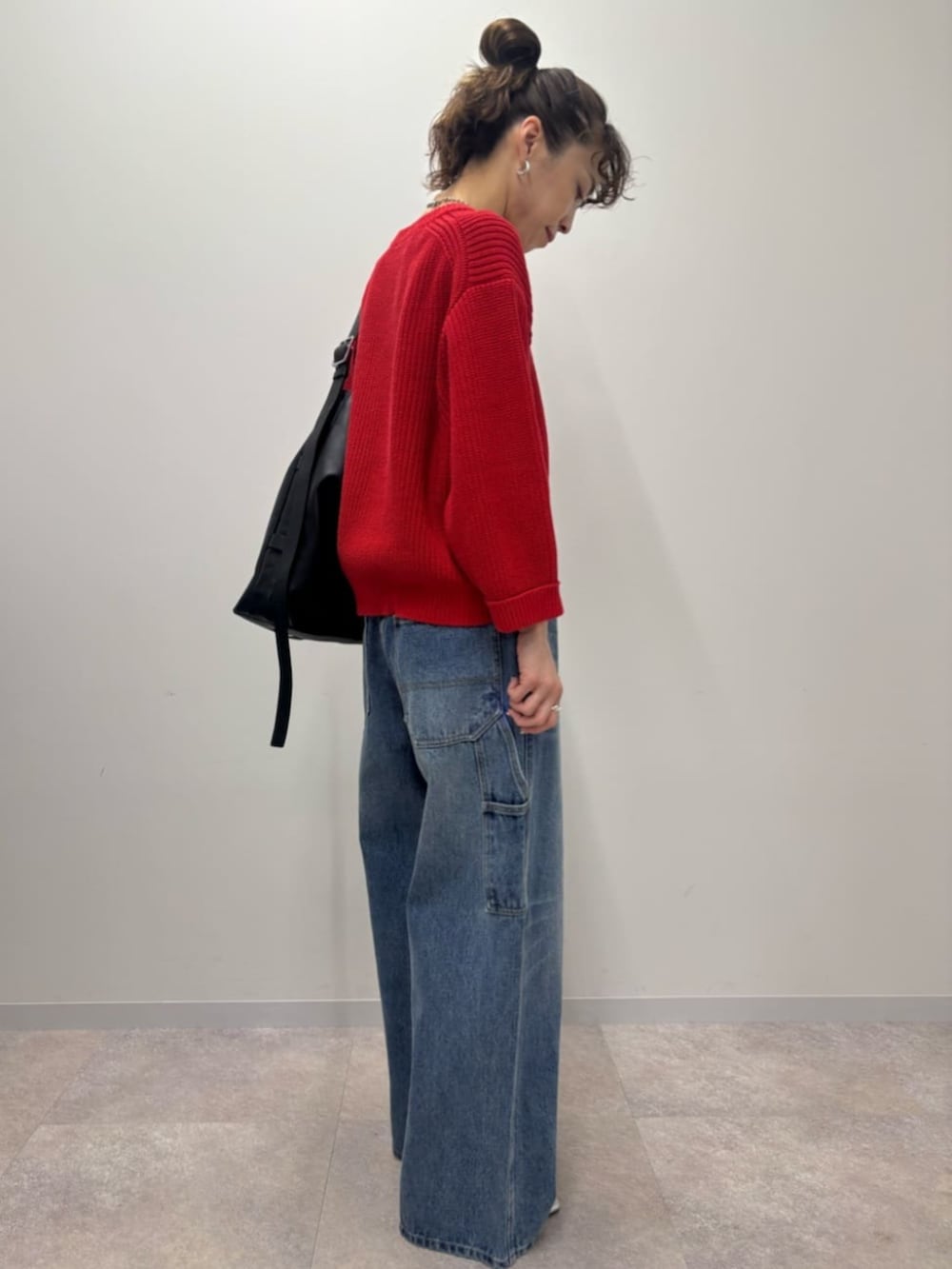 レッド系のニット/セーターを着用したレディースの冬コーディネートの2枚目の写真