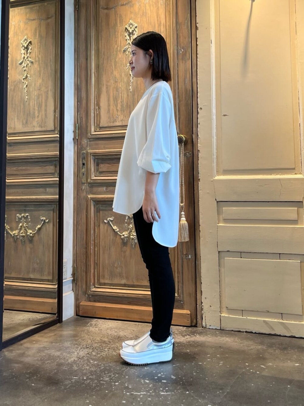 シルバー系のスニーカー、ブラック系のその他パンツ、ホワイト系のシャツ/ブラウスを着用したレディースの冬コーディネートの2枚目の写真