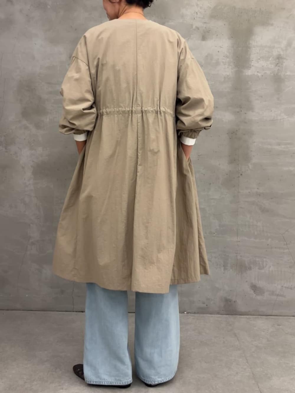 ベージュ系のその他アウター、ブラック系のボストンバッグ、ブルー系のデニムパンツを着用したレディースの冬コーディネートの6枚目の写真