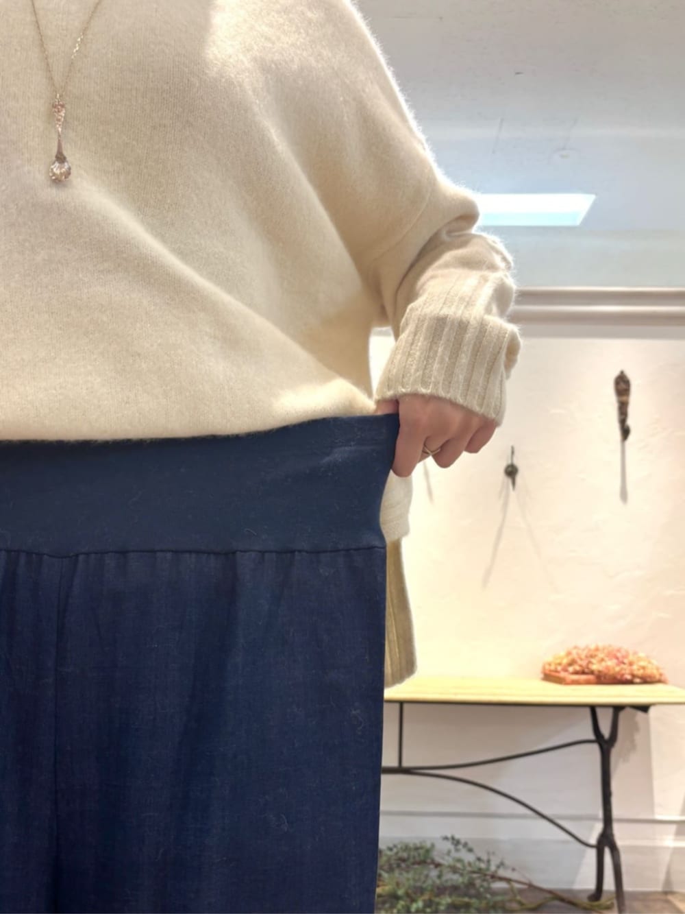 ブルー系のその他パンツ、グリーン系のハンドバッグ、ホワイト系のニット/セーターを着用したレディースの冬コーディネートの7枚目の写真