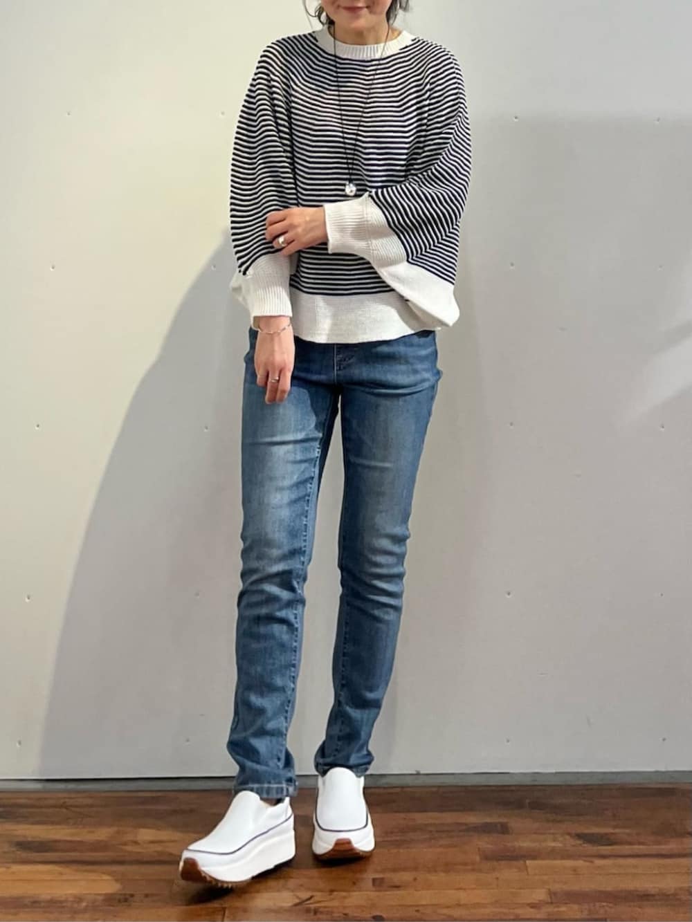 ブルー系のデニムパンツ、ブルー系のニット/セーターを着用したレディースの春コーディネートの7枚目の写真