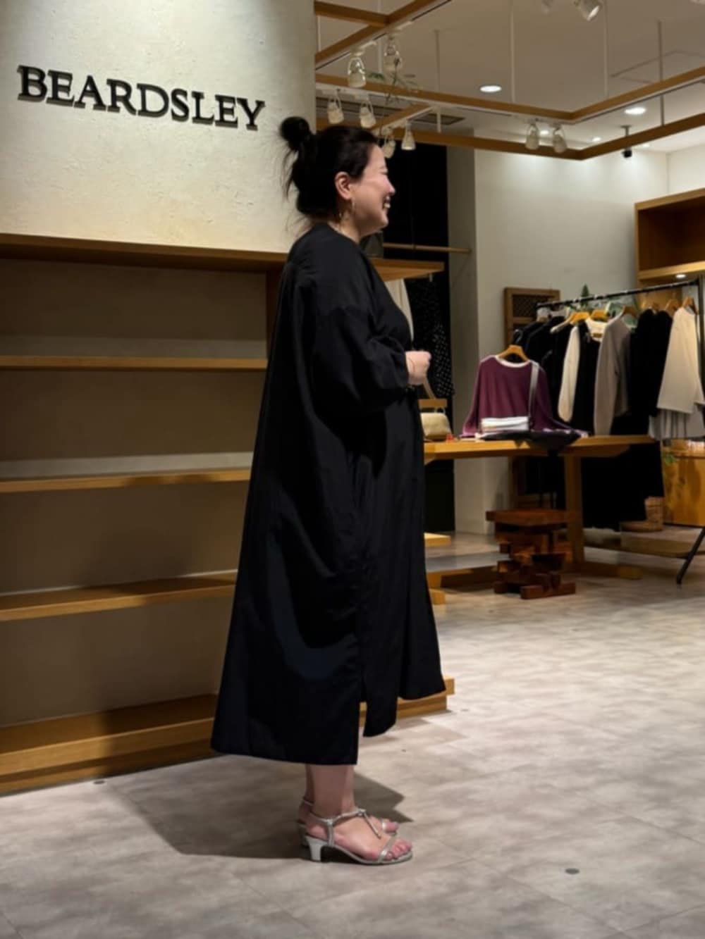 グリーン系のハンドバッグ、ブラック系のワンピースを着用したレディースの冬コーディネートの3枚目の写真