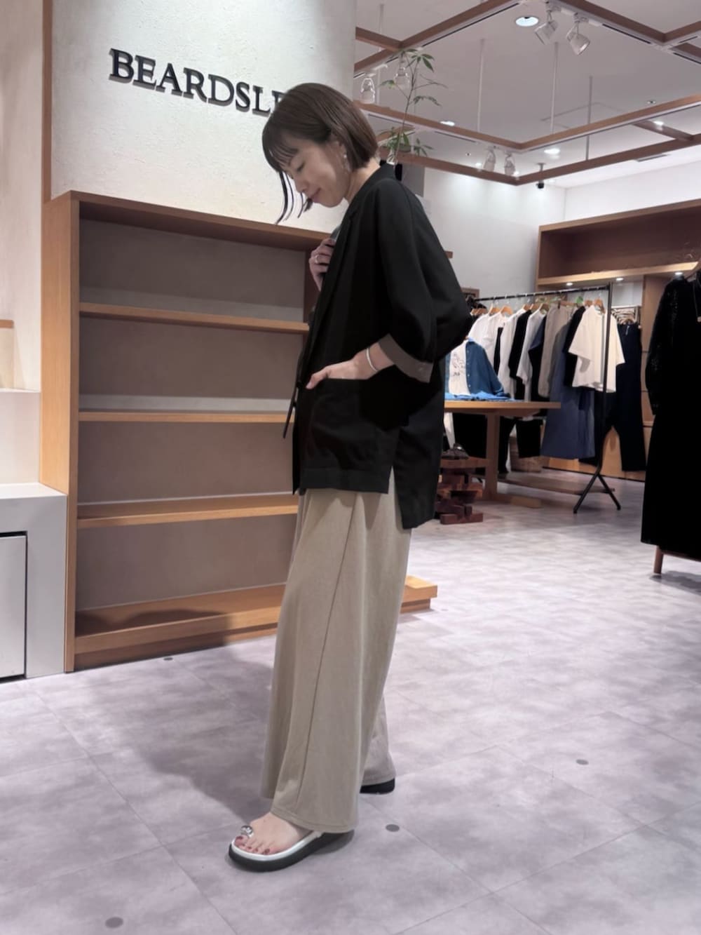 ブラック系のテーラードジャケット、ベージュ系のその他パンツ、ホワイト系のサンダルを着用したレディースの春コーディネートの8枚目の写真